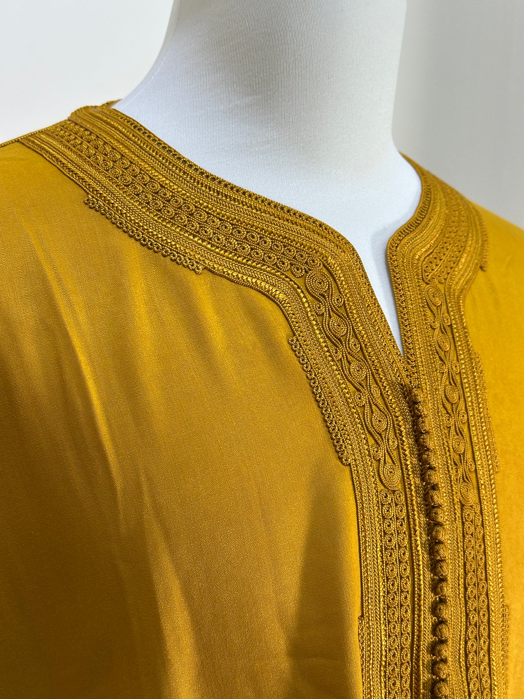 mannequin portant gandoura homme matiere mlifa de couleur moutarde avec un travail motifs fait main vue details-rapproches